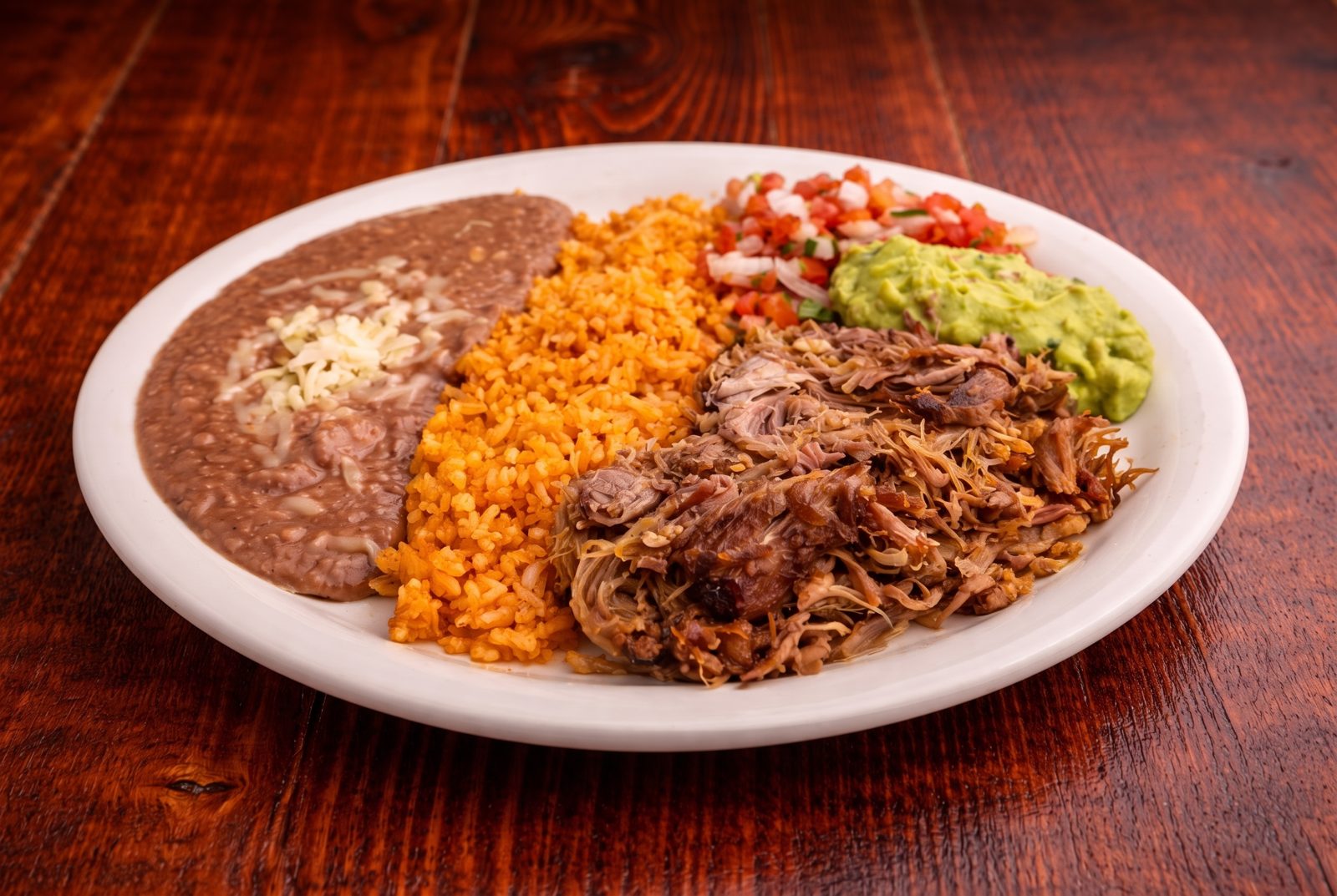 Carnitas plate with rice, beans, pico de gallo and guacamole